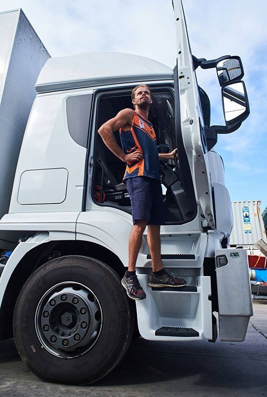 A Man Is Standing On The Steps Of A Semi Truck — Dawson Moving & Storage NQ in Mount St John, QLD