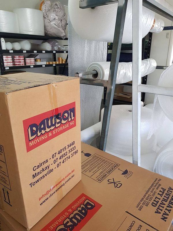 A Cardboard Box Is Sitting On Top Of A Pile Of Cardboard Boxes — Dawson Moving & Storage NQ in Mount St John, QLD