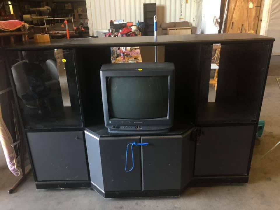 A Television Is Sitting On Top Of A Black Entertainment Center — Dawson Moving & Storage NQ in Mount St John, QLD