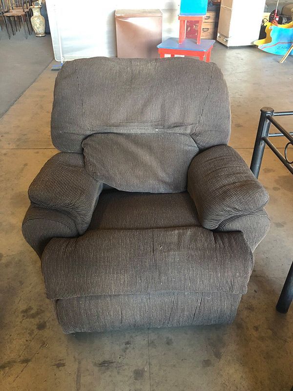 A Brown Recliner Is Sitting On A Concrete Floor In A Room — Dawson Moving & Storage NQ in Townsville, QLD