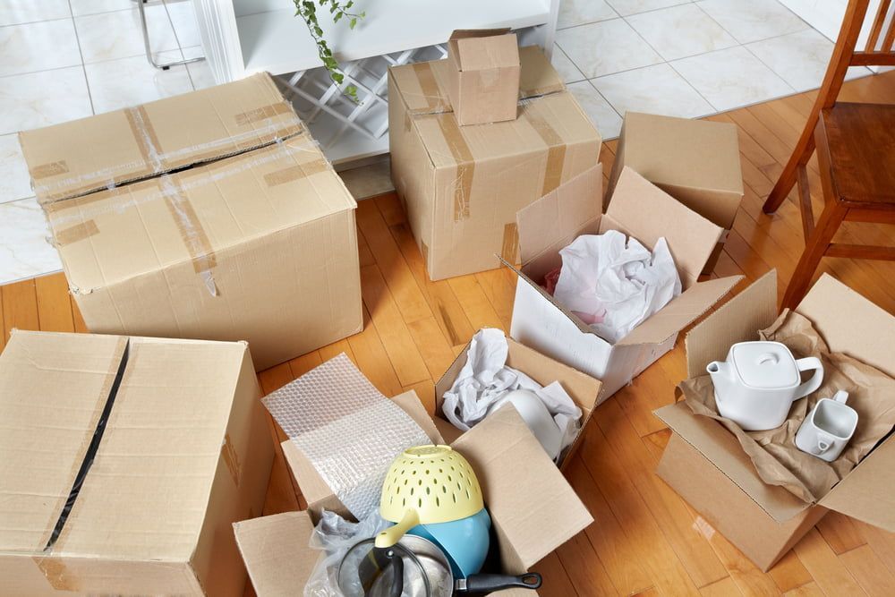 A Bunch Of Cardboard Boxes Are Sitting On The Floor In A Living Room — Dawson Moving & Storage NQ In Mount St John, QLD
