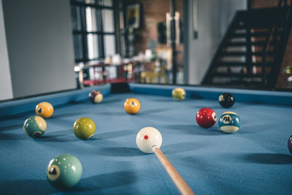 A Pool Table With Pool Balls And A Cue On It — Dawson Moving & Storage NQ in Mount St John, QLD