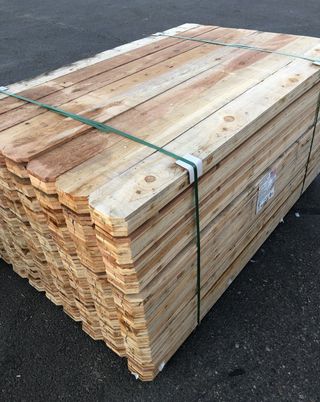 A stack of wooden boards tied together with a green strap