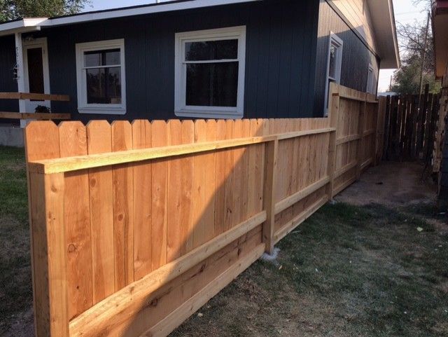 A house with a wooden fence in front of it