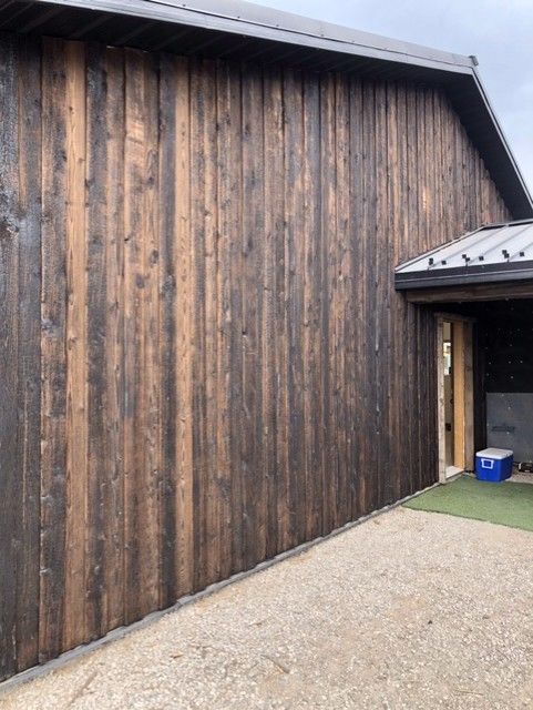A large wooden building with a blue cooler in front of it.