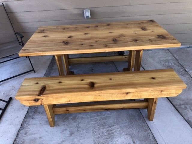 A wooden table with two benches on a patio