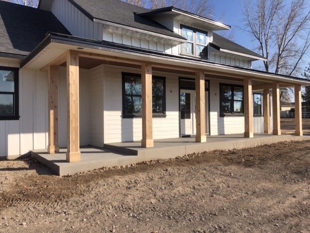 A white house with a porch and a lot of windows