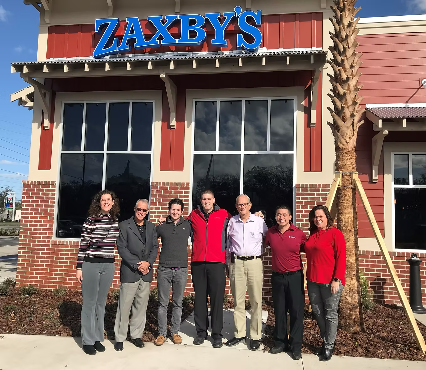 Group of people posing in front of a Zaxby's restaurant.
