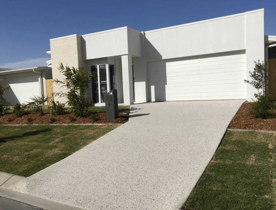 White modern house with a concrete driveway and garage door.