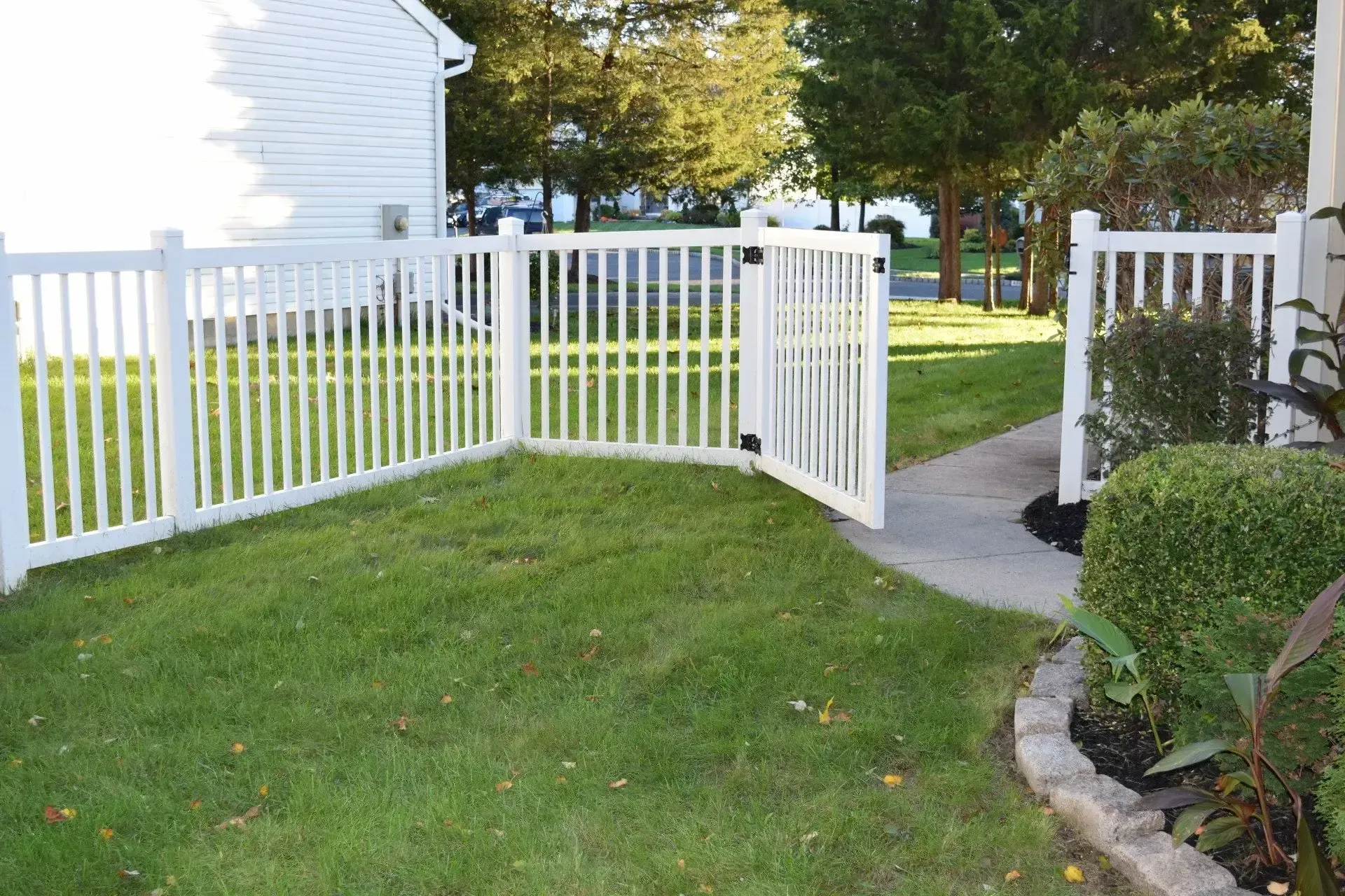 A white picket fence in Columbus Ga surrounds a lush green yard.