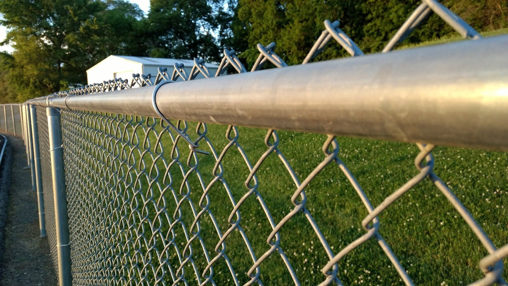 A wooden fence is sitting in the middle of a dirt field in front of a house.