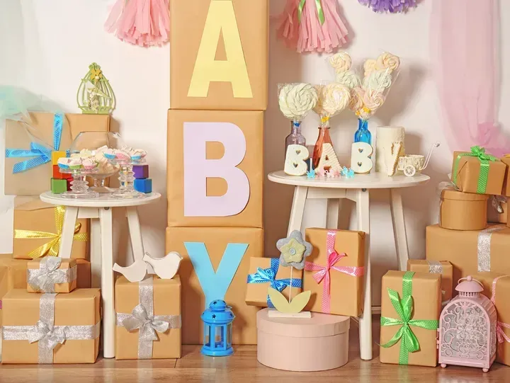 Baby shower decor with wrapped gifts, block letters spelling
