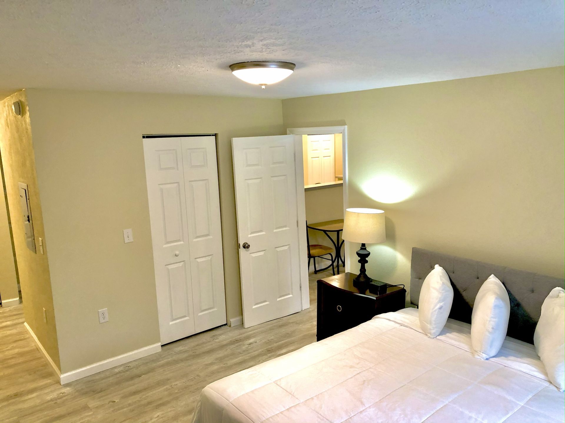 Bedroom with a bed, doors, and a lamp.