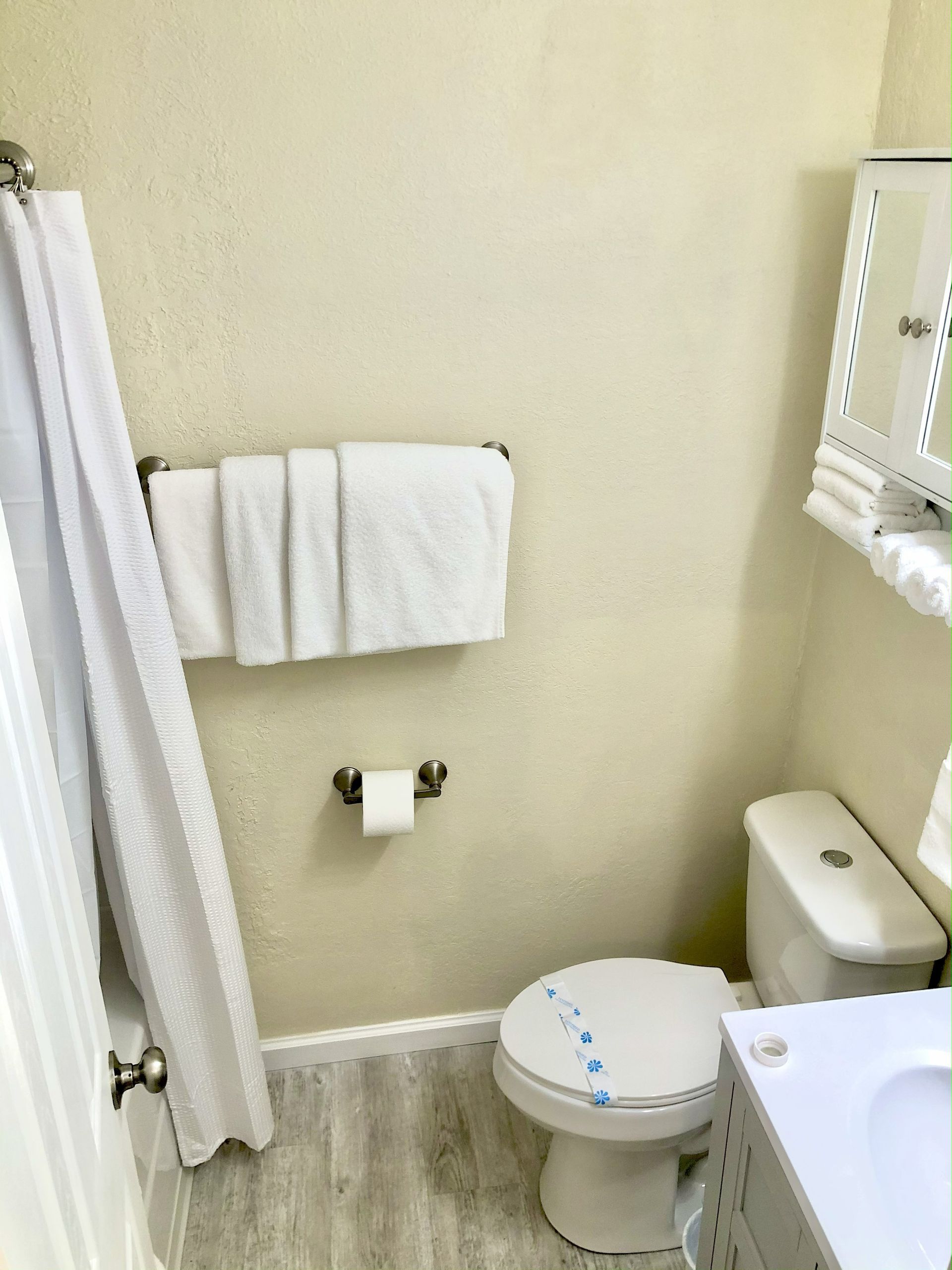 Small bathroom with toilet, towels, and a shower curtain.