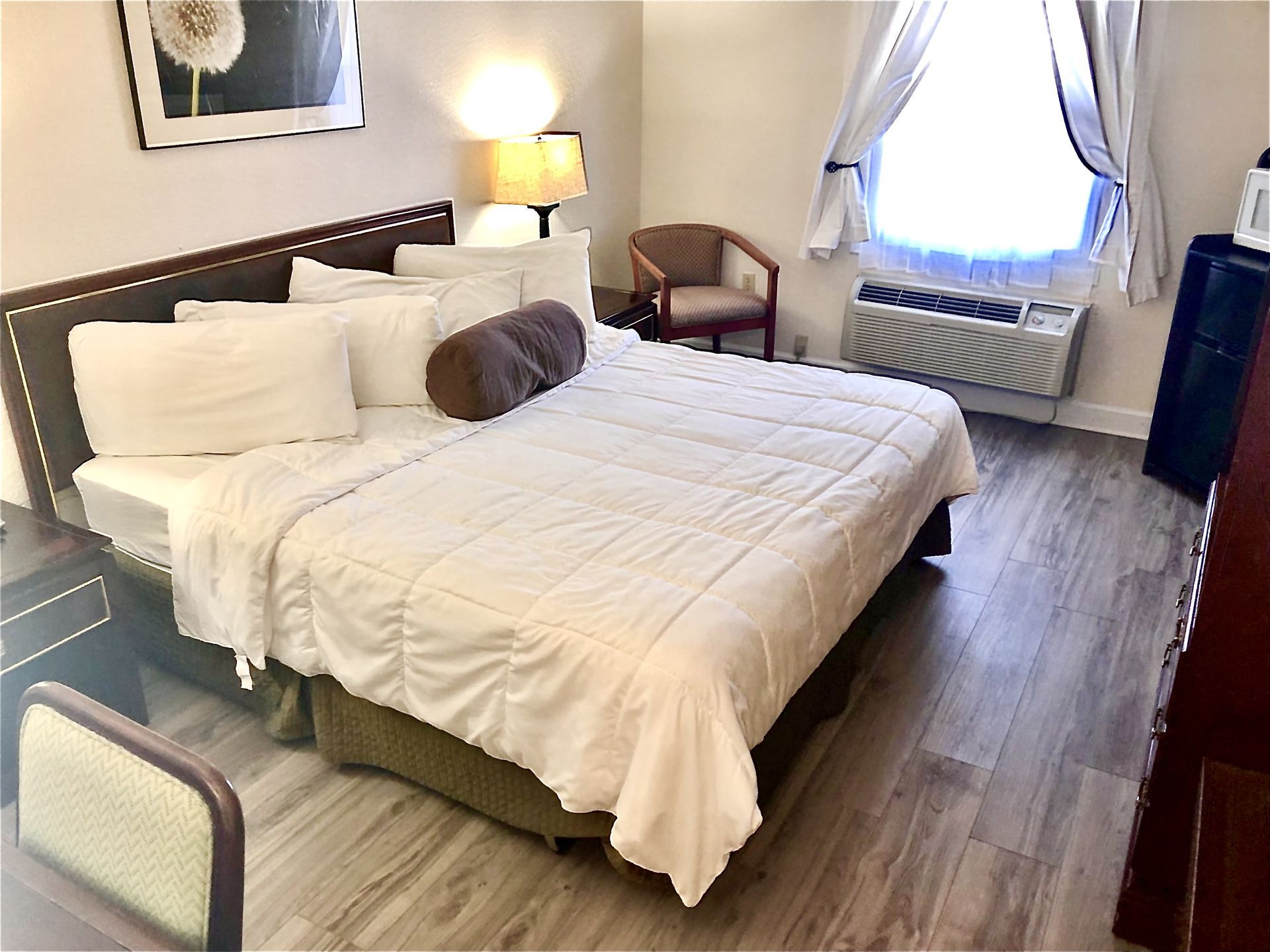 Bedroom with bed, desk, dresser, and lamps.