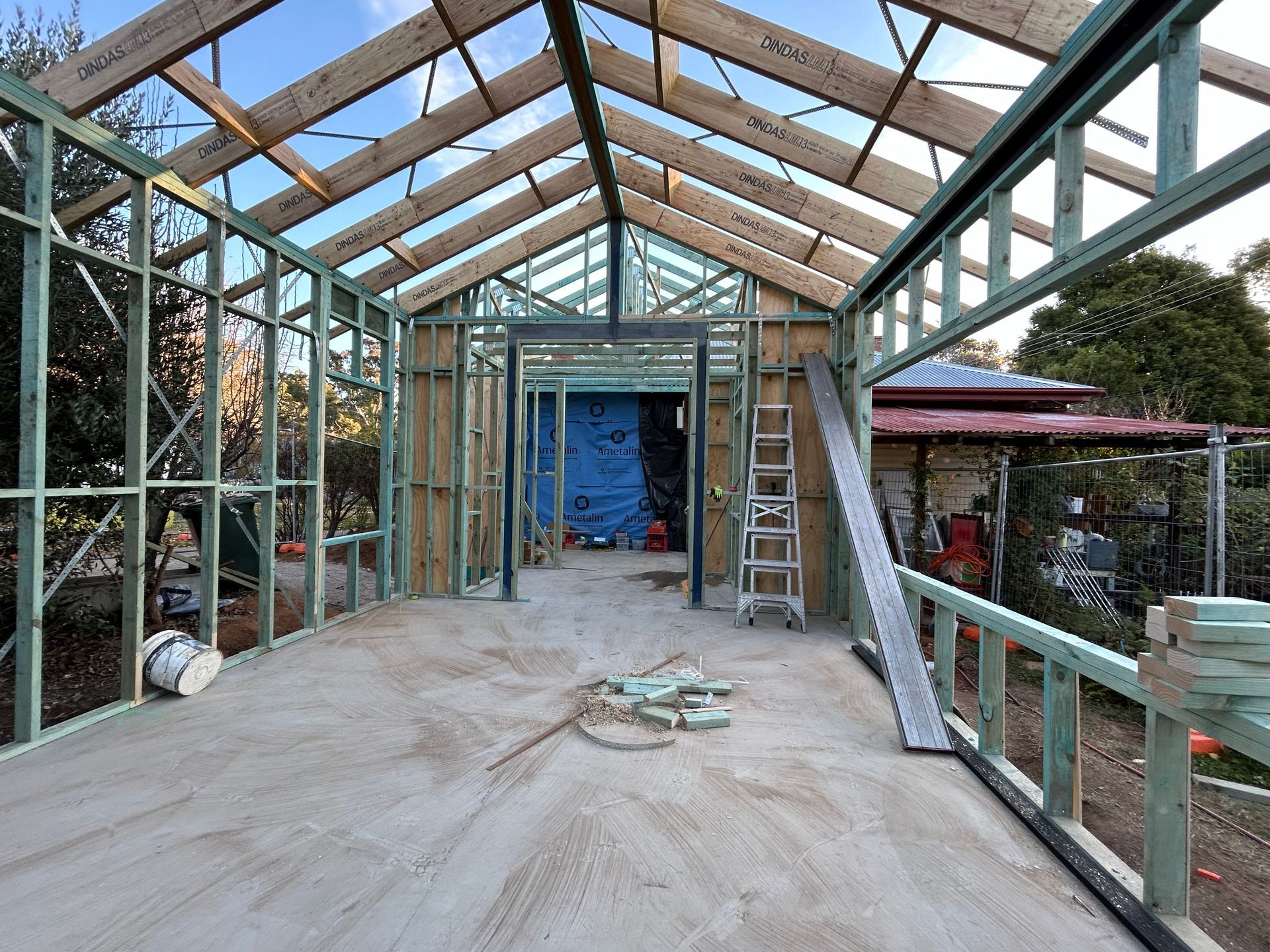 Interior view of a building under construction, showing wooden frame, concrete floor, and visible roof beams. — Straight up Building Projects in Holt, ACT