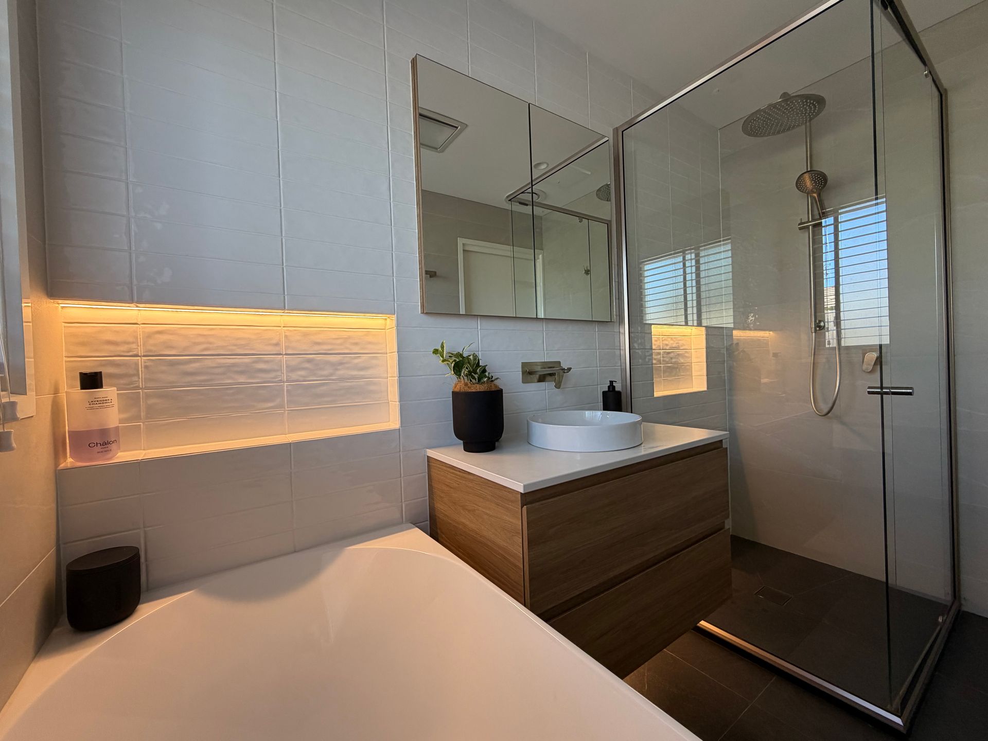 Modern bathroom with a bathtub, vanity, and glass shower. White and wood tones, recessed lighting. — Straight up Building Projects in Holt, ACT
