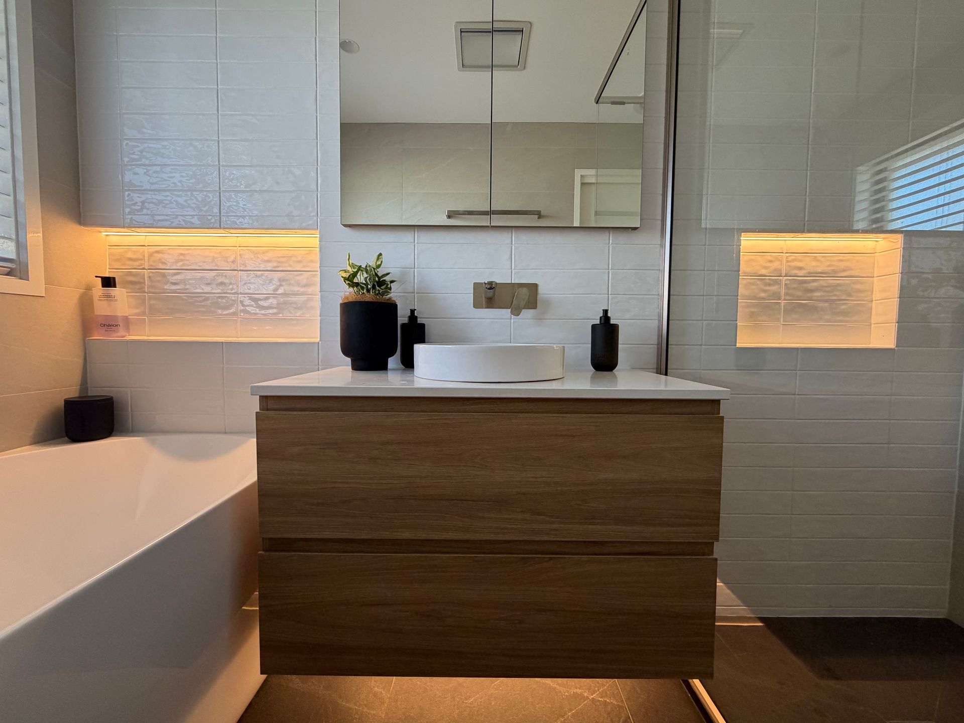 Modern bathroom with floating wooden vanity, white vessel sink, and recessed lighting. — Straight up Building Projects in Holt, ACT
