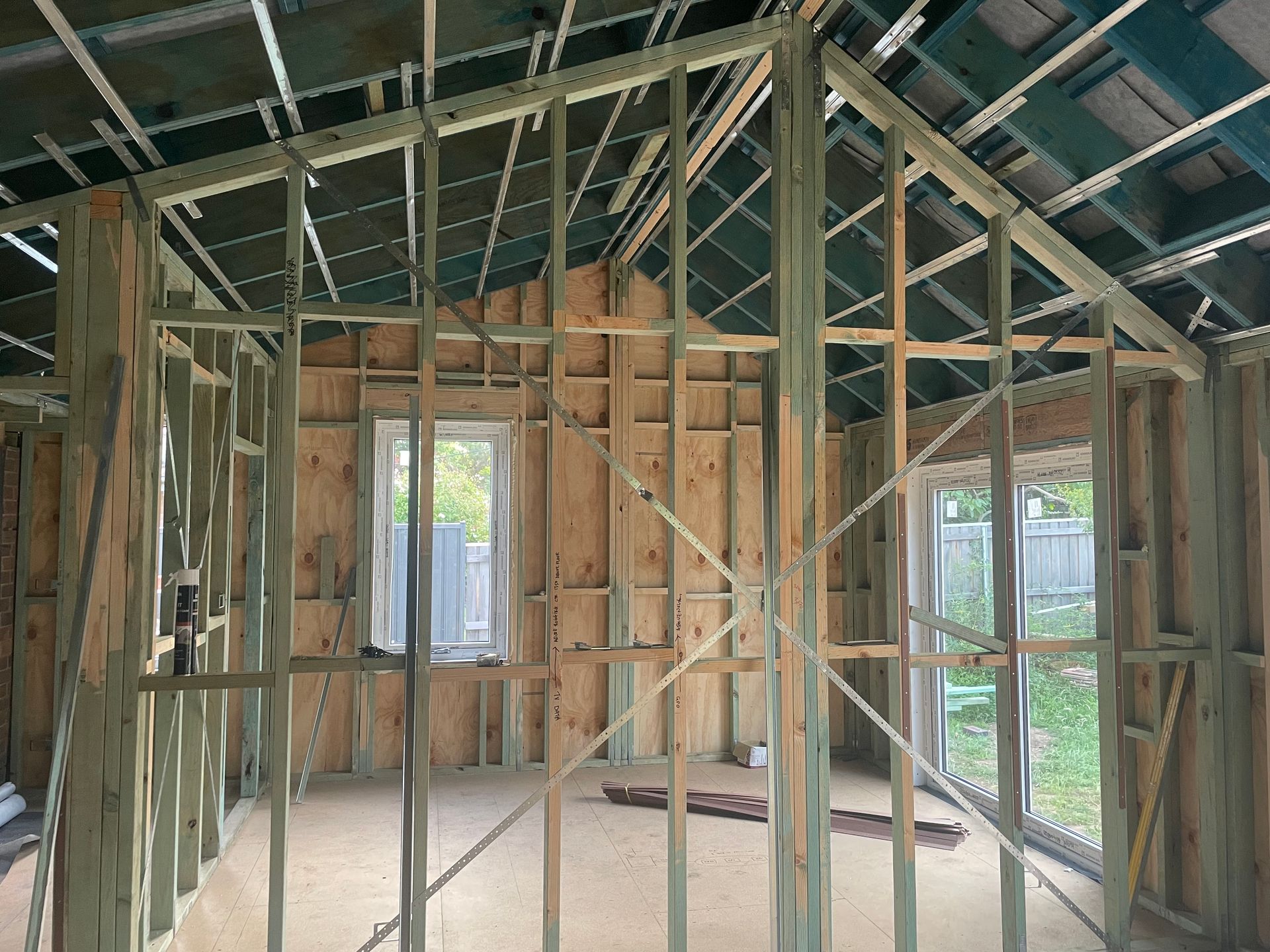 Interior view of a building under construction, showing wooden framing for walls, windows, and a doorway. — Straight up Building Projects in Holt, ACT