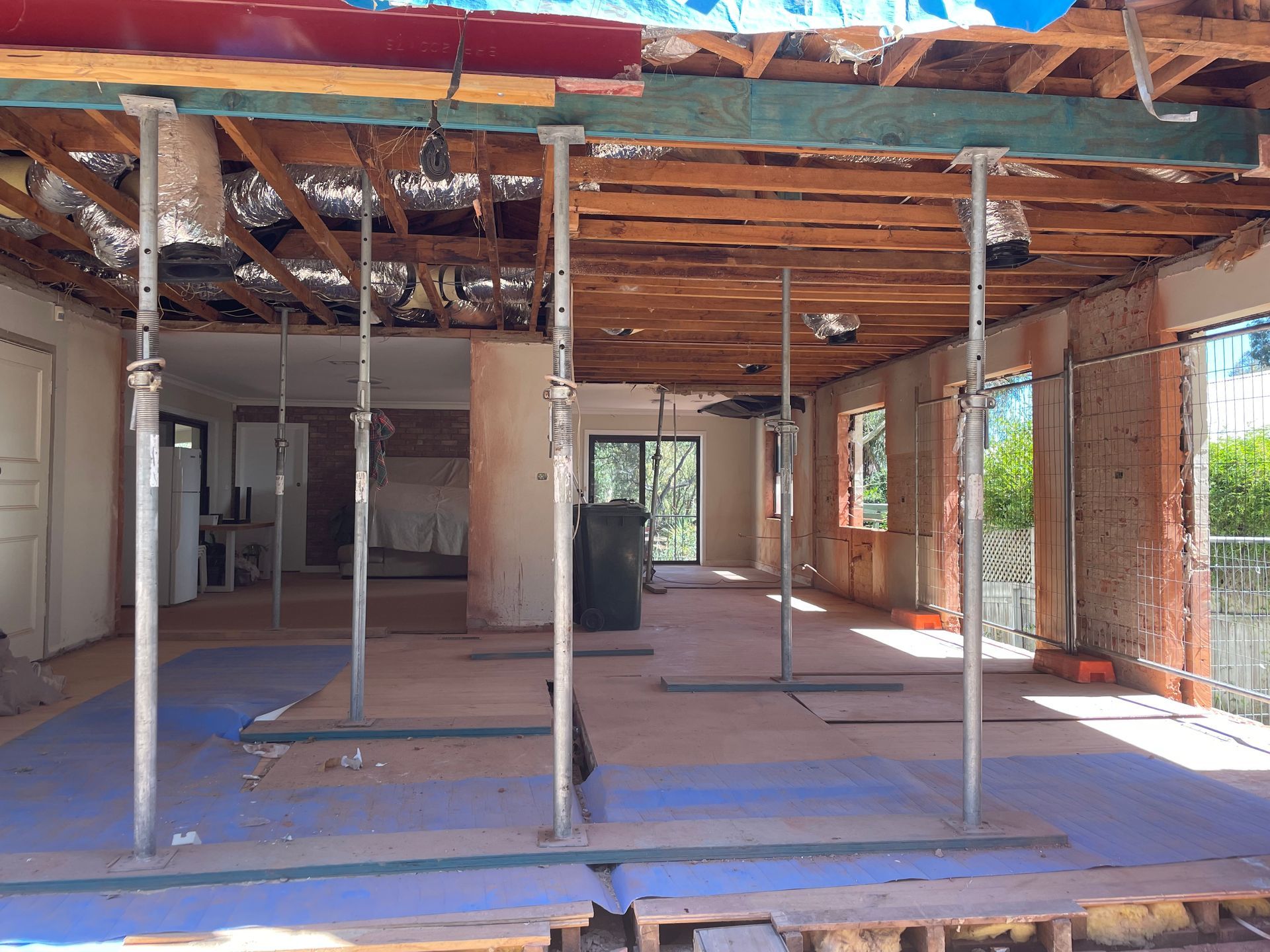 Interior of a building under renovation, supported by steel props. Exposed ceiling beams and incomplete walls are visible. — Straight up Building Projects in Holt, ACT