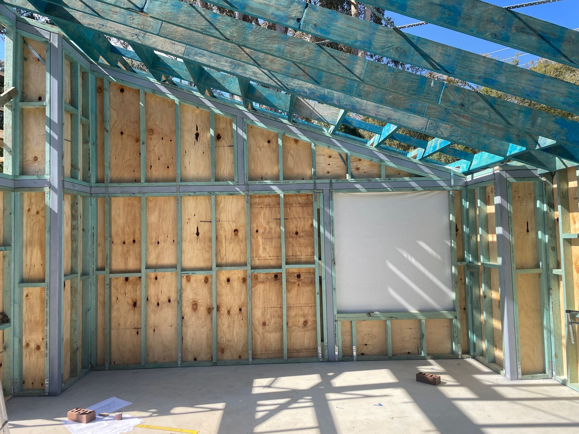 Interior framing of a building under construction, with wooden studs and plywood sheathing. — Straight up Building Projects in Holt, ACT