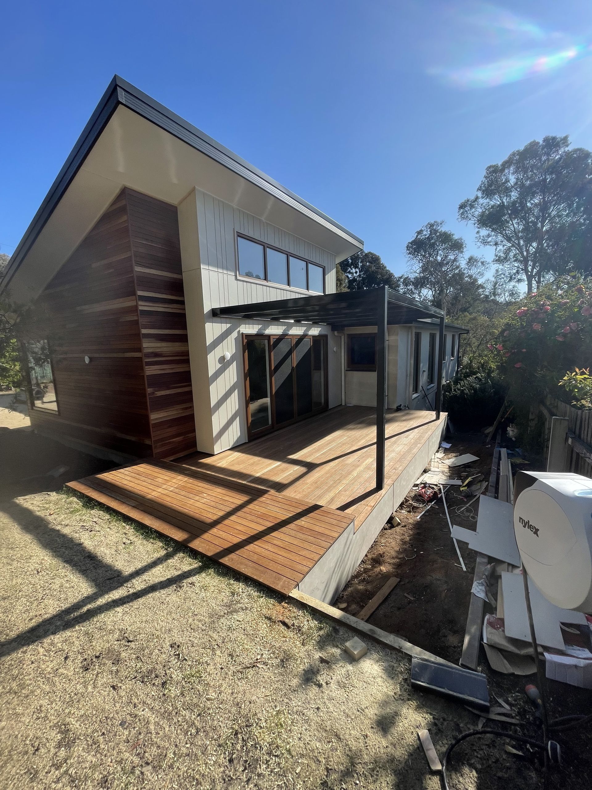 A modern, two-story house with a wooden facade, large windows, and a newly constructed wooden deck under a pergola — Straight up Building Projects in Weston Creek, ACT