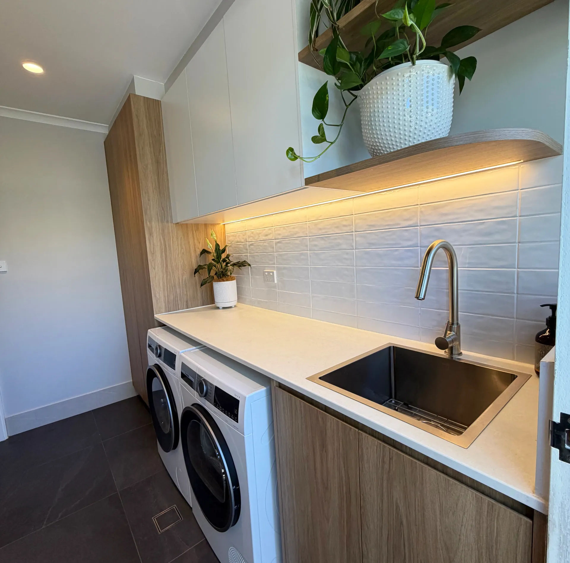 A Renovated Laundry With Wooden Cabinets And Washer And Dryer — Straight up Building Projects in Holt, ACT