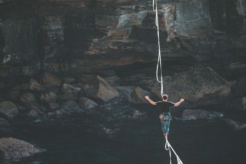 Woman taking a risk by walking on a rope.