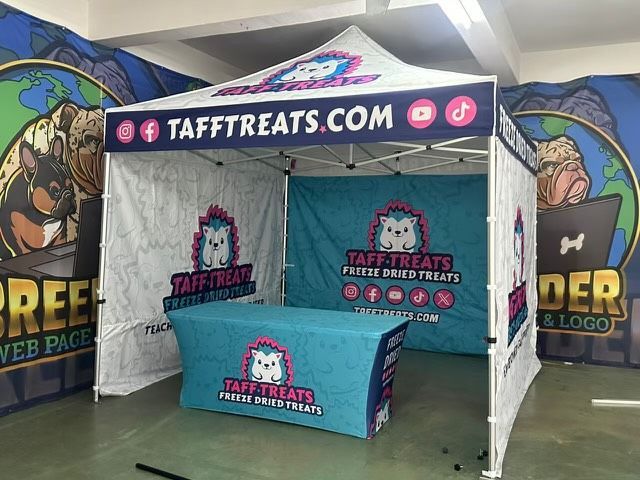TAFFTREATS.com booth with teal table, white tent, and colorful branded banners at an indoor event