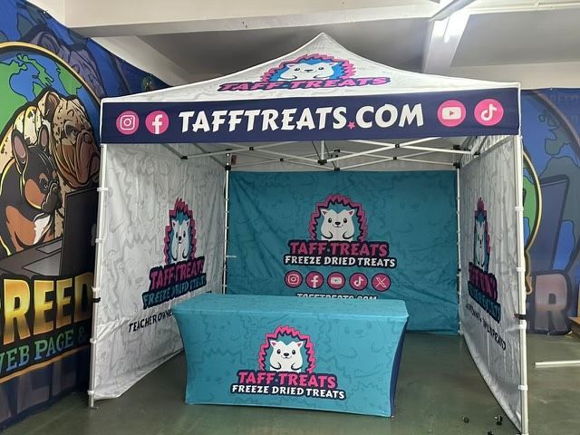 TaffTreats.com booth with teal tablecloth and banner at an indoor event
