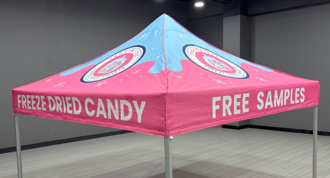 Pink freeze-dried candy canopy tent with “FREE SAMPLES” signage at an indoor event booth