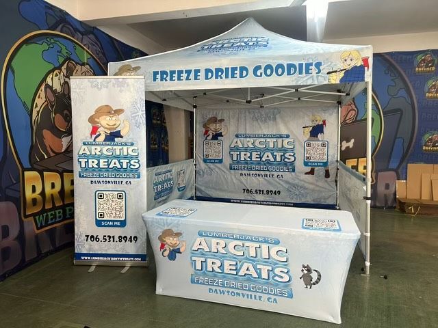 Arctic Treats display booth with freezer cases and branded signs under a “Freeze Dried Goodies” banner.