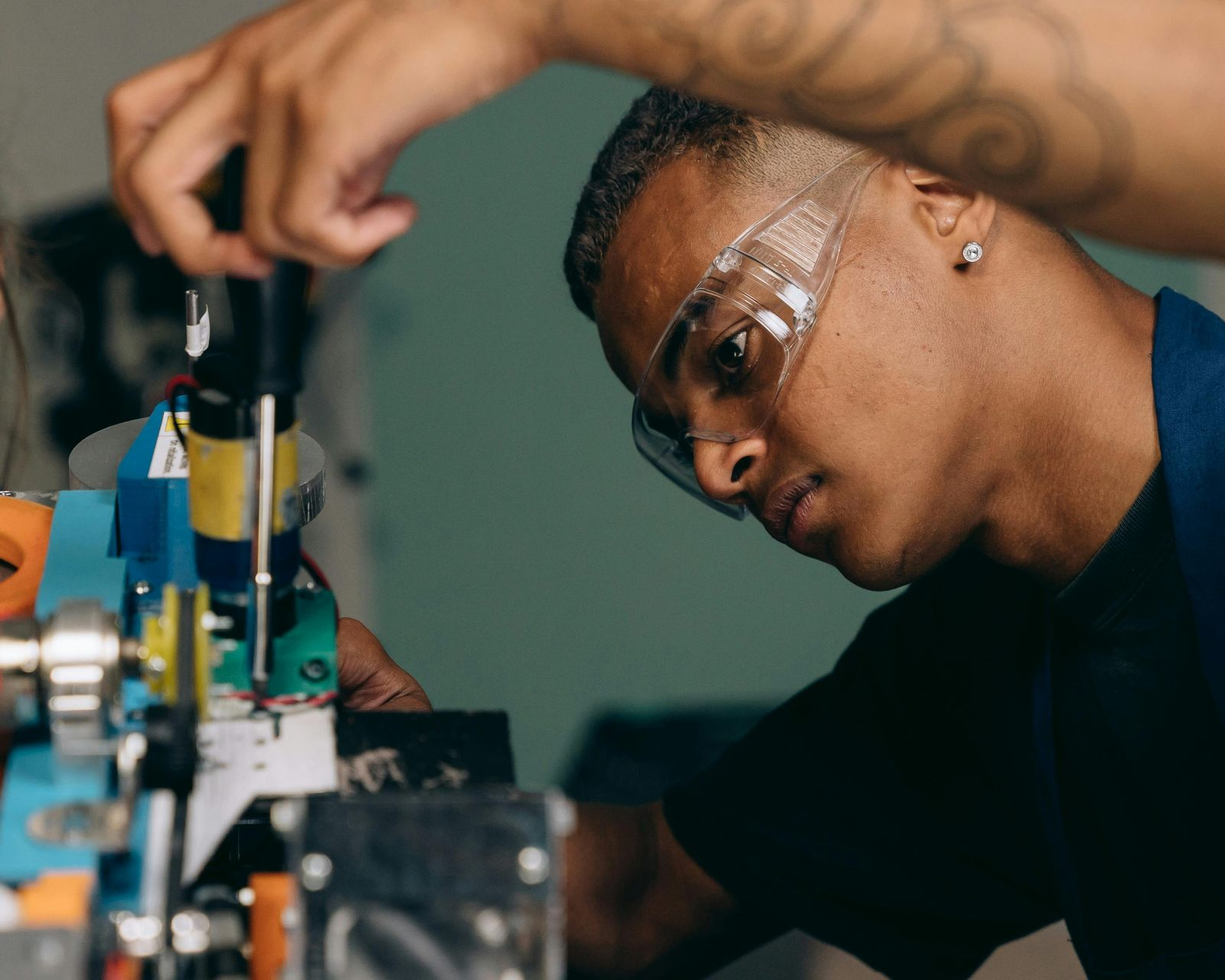 Man calibrating digital scales, wearing safety glasses and a blue apron. Sooner Scale