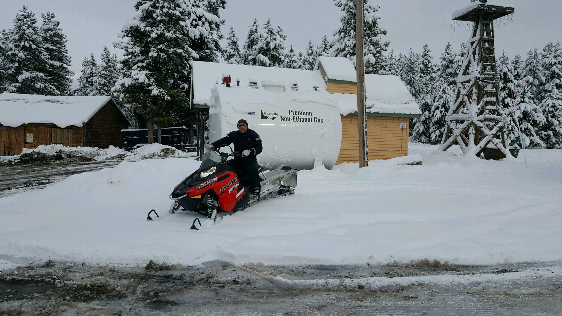 A man sitting on a red snowmobile