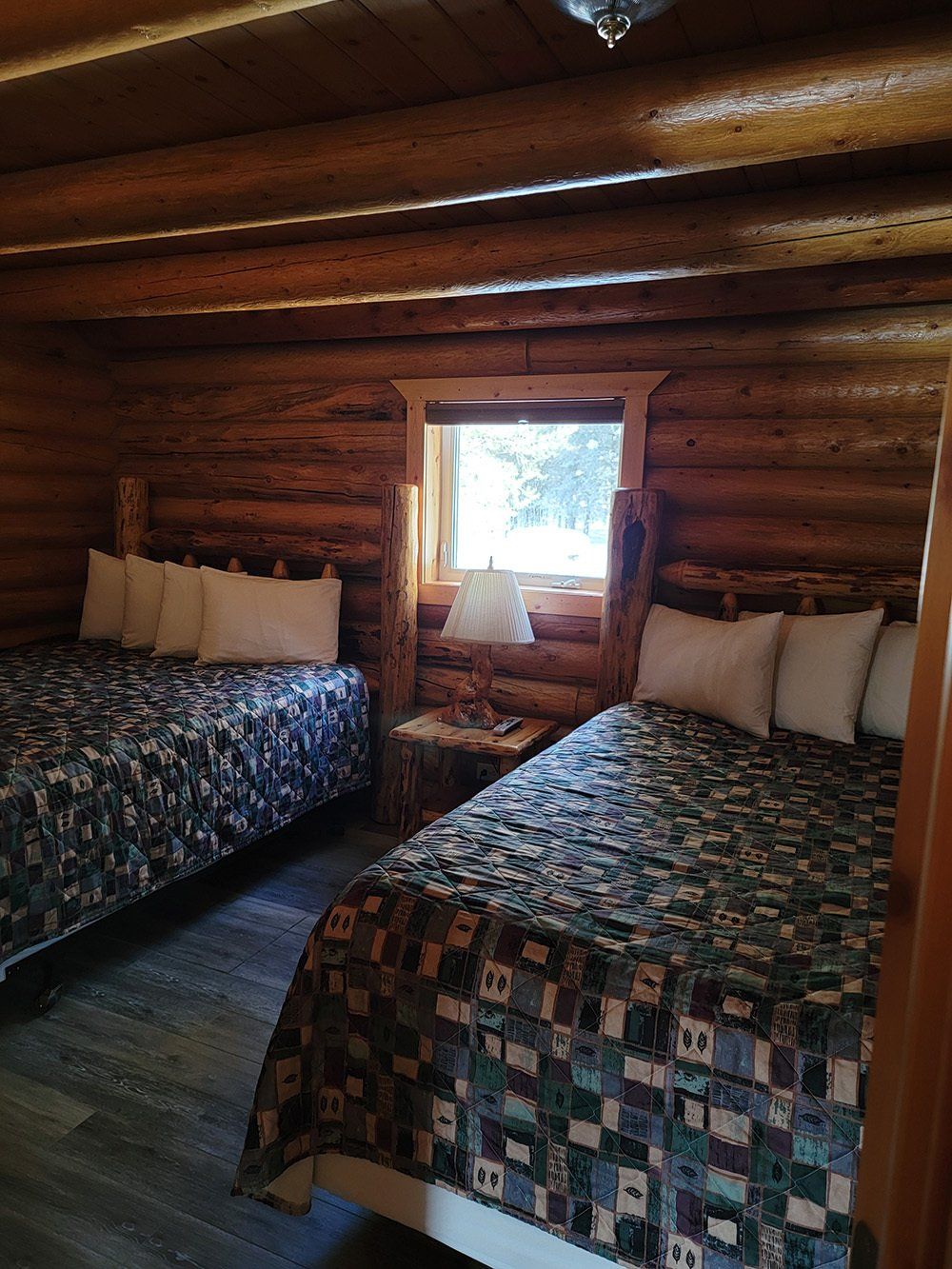 Two beds with lamp shade in the middle