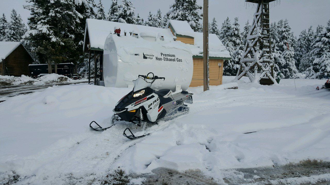 White snowmobile parked outside a cabin