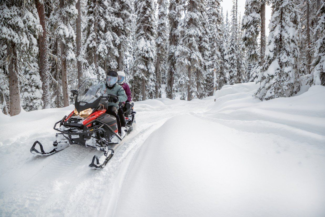 Two people riding a snowmobile