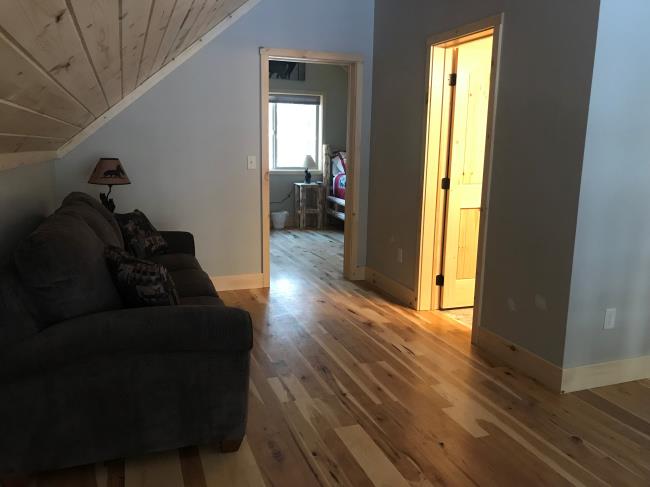 Black couch outside a bedroom
