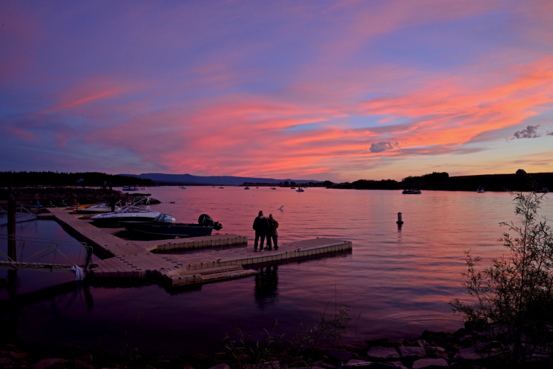 pink sunset over couple standing on dock