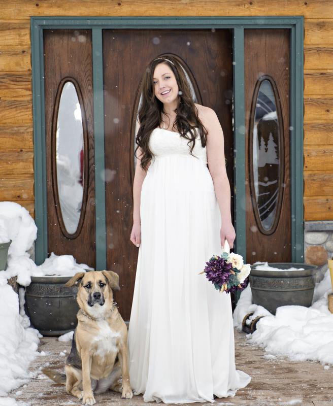 A bride posing for a photo with her dog