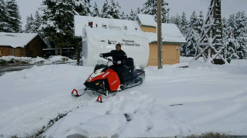 A man sitting on a red snowmobile