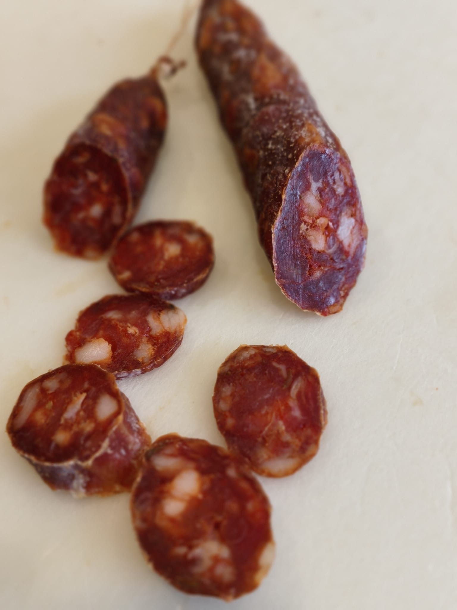 Prodotti a base di carne esposti in un banco refrigerato, tra cui salsicce confezionate e carne macinata.