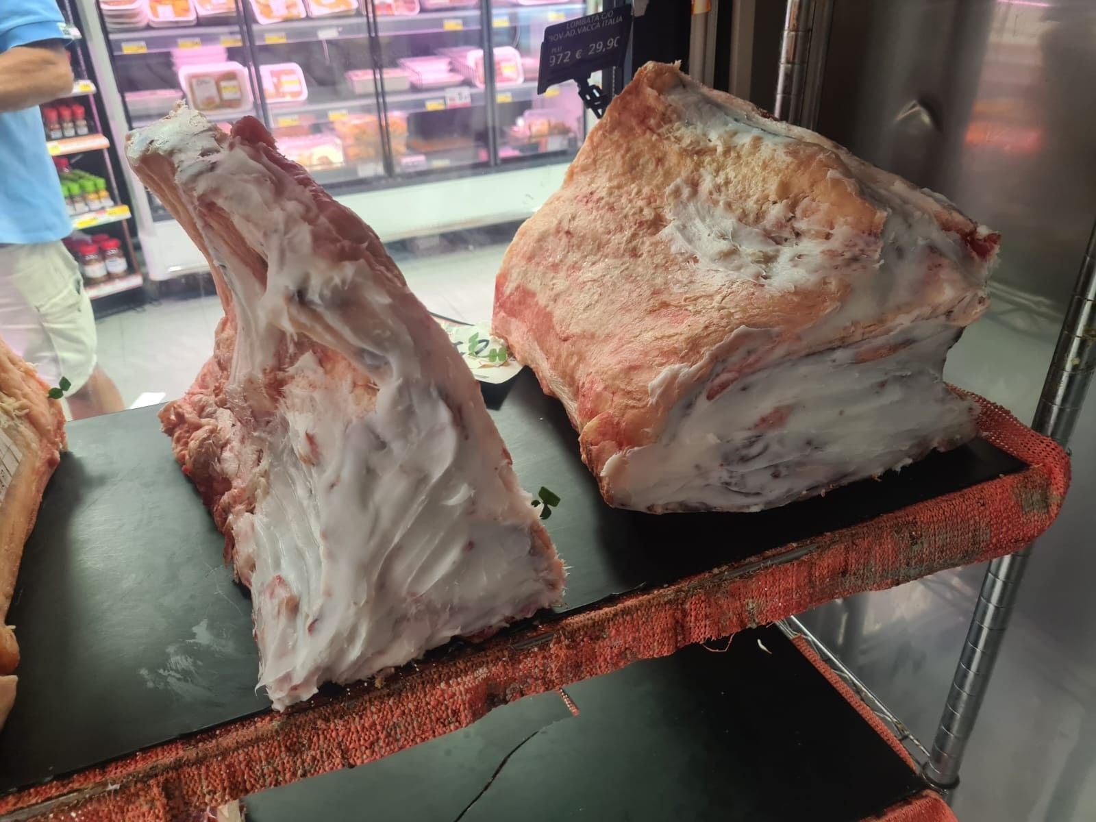 Due grandi tagli di carne cruda, probabilmente manzo, esposti sul bancone di una macelleria.