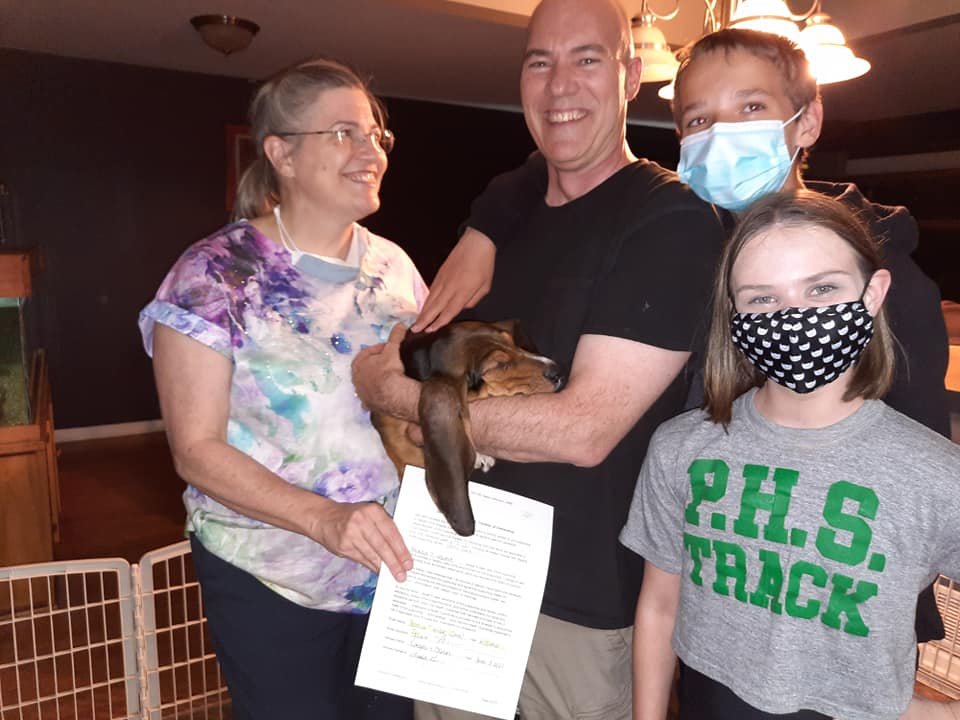 A family wearing face masks and a p.h.s track shirt