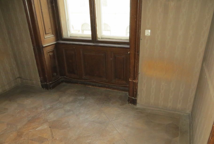 Ein leerer Raum mit einem Fenster und Holzschränken.