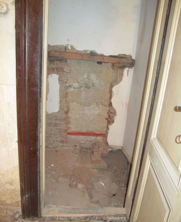 Eine Tür steht zu einem Raum mit einer Ziegelwand offen