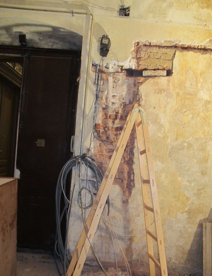 Eine Holzleiter lehnt an einer Wand in einem Raum