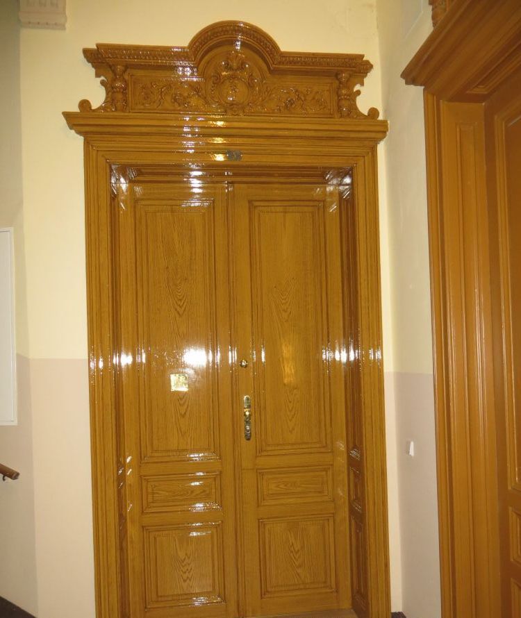 Eine Holztür in einem Raum mit einer weißen Wand