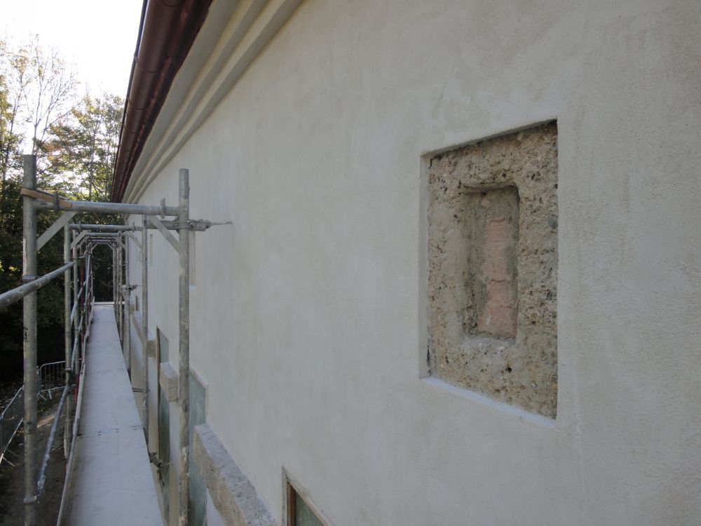 Eine weiße Wand mit einem Loch darin und einem Gerüst darum herum