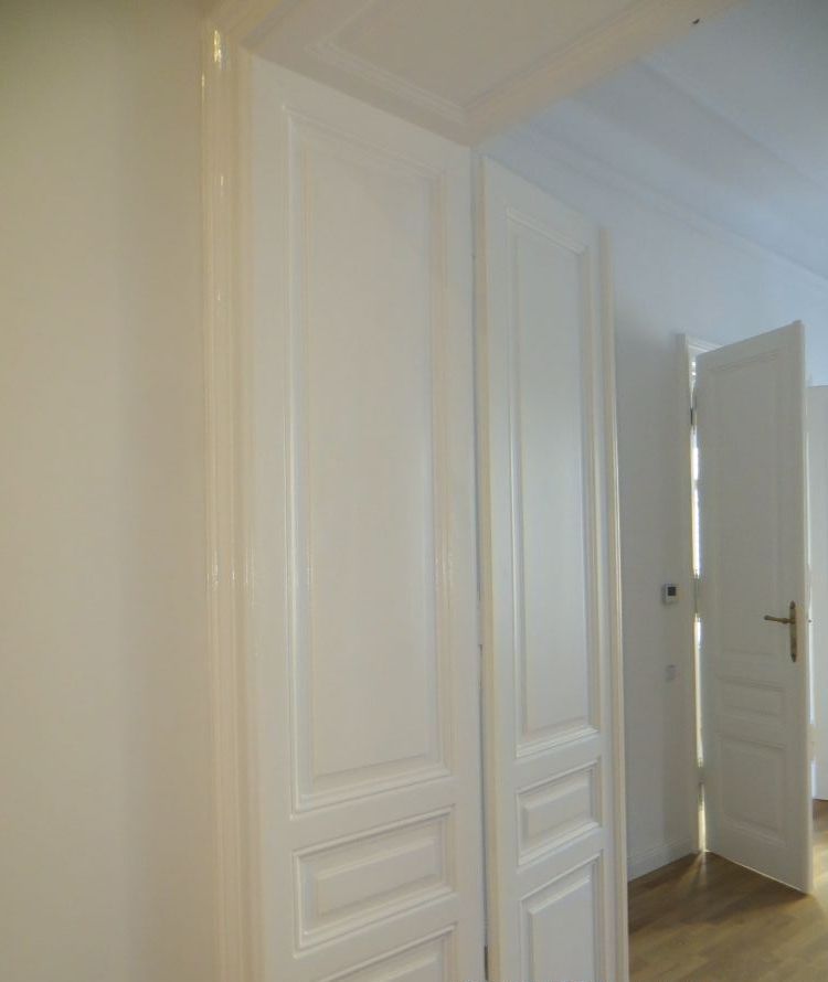 Ein Flur mit weißen Türen und einer offenen Tür.